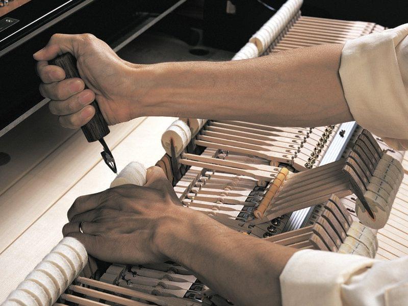 Imagen de un técnico trabajando en el interior de un piano